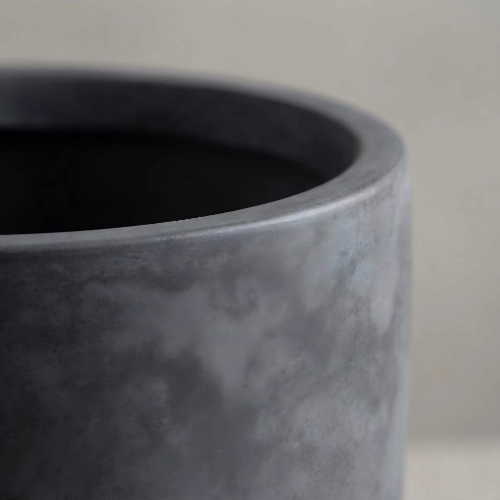 About Kante 3 Close-up detail showing the smooth handmade finish and premium texture of a Kante charcoal grey concrete planter.