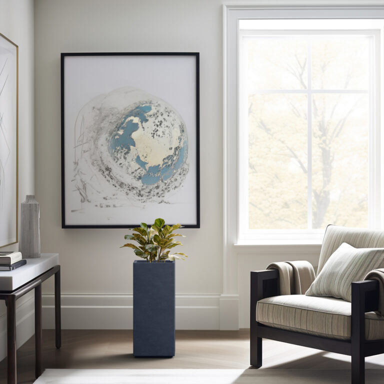 Dark gray KANTE tall square concrete planter beside an armchair and window.