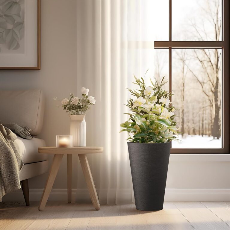 Black KANTE tapered plastic planter with white flowers beside a living room window.